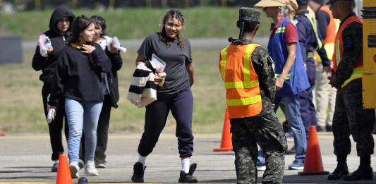 Personas deportadas llegan en un avión militar estadounidense, a la base aérea Armando Escalon ubicada en San Pedro Sula. Foto La Hora: EFE.