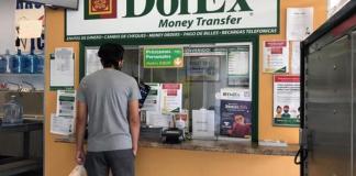 Una persona espera a que le atiendan en un local de envío de remesas en Downey, California. Foto La Hora: EFE Archivo.