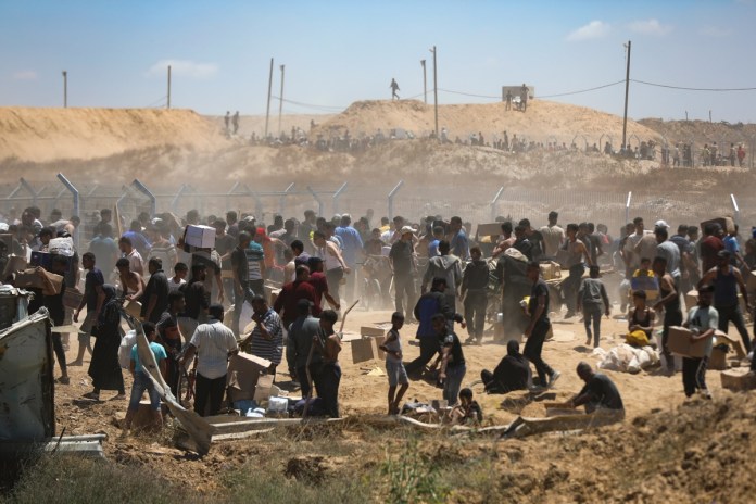 Reportan cuatro palestinos muertos luego de qué multitudes hambrientas irrumpieran un almacén de alimentos Palestinos transportan suministros de ayuda recibidos de la Fundación Humanitaria de Gaza. Foto La Hora: EFE