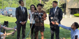 Marcelo Gomes da Silva, de 18 años, al centro, un estudiante de secundaria de Massachusetts que llegó a Estados Unidos cuando tenía 7 años de edad y fue detenido por agentes del Servicio de Inmigración y Control de Aduanas el sábado 31 de mayo de 2025, habla con la prensa después de ser liberado bajo fianza, acompañado de los representantes Seth Moulton, un demócrata por Massachusetts, a la derecha, y Jake Auchincloss, también demócrata del estado, el jueves 5 de junio de 2025, en Burlington, Massachusetts. (AP Foto/Rodrique Ngowi)