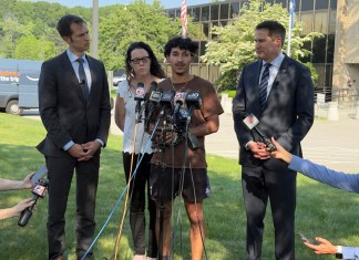 Marcelo Gomes da Silva, de 18 años, al centro, un estudiante de secundaria de Massachusetts que llegó a Estados Unidos cuando tenía 7 años de edad y fue detenido por agentes del Servicio de Inmigración y Control de Aduanas el sábado 31 de mayo de 2025, habla con la prensa después de ser liberado bajo fianza, acompañado de los representantes Seth Moulton, un demócrata por Massachusetts, a la derecha, y Jake Auchincloss, también demócrata del estado, el jueves 5 de junio de 2025, en Burlington, Massachusetts. (AP Foto/Rodrique Ngowi)