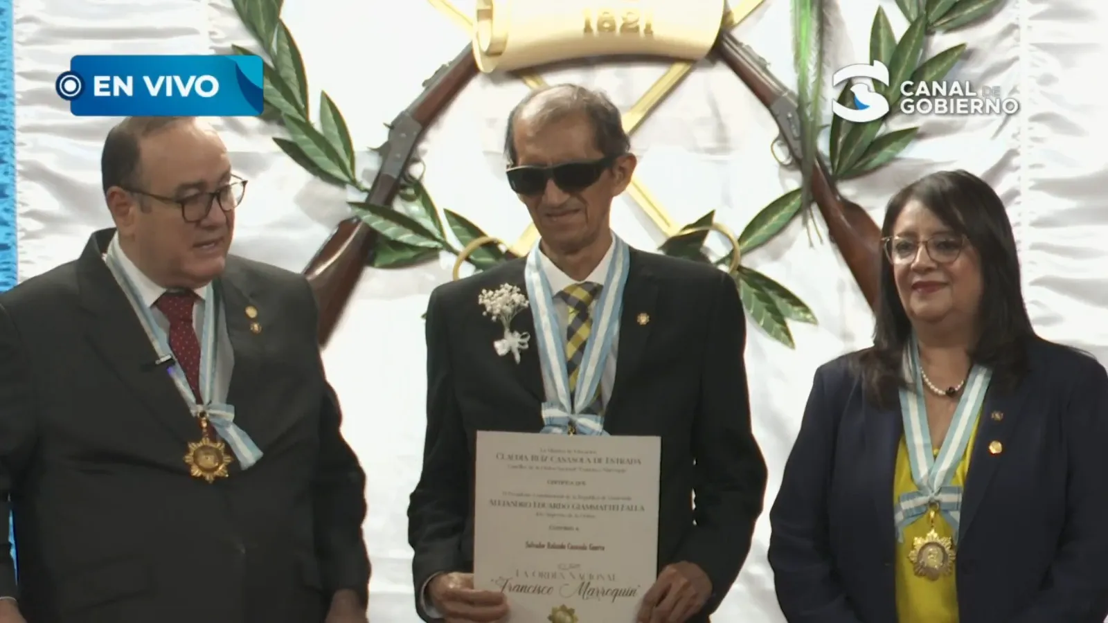 El expresidente Alejandro Giammattei y la exministra de Educación, Claudia Ruíz entregaron una distinción a Salvador Casasola. Foto La Hora: Gobierno de Guatemala
