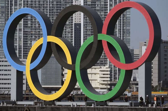Foto del primero del 2024, los anillos olímpicos siendo reinstalados tras removerlos para darles mantenimiento previo a los Juegos Olímpicos de Tokio 2020. (AP Foto/Eugene Hoshiko, Archivo)