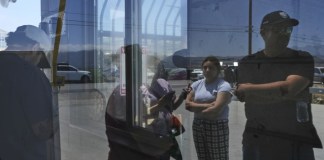 Personas esperan afuera de Glass House Farms, un día después de una redada de inmigración en las instalaciones, el viernes 11 de julio de 2025, en Camarillo, California. (Foto AP/Jae C. Hong)