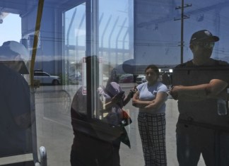 Personas esperan afuera de Glass House Farms, un día después de una redada de inmigración en las instalaciones, el viernes 11 de julio de 2025, en Camarillo, California. (Foto AP/Jae C. Hong)