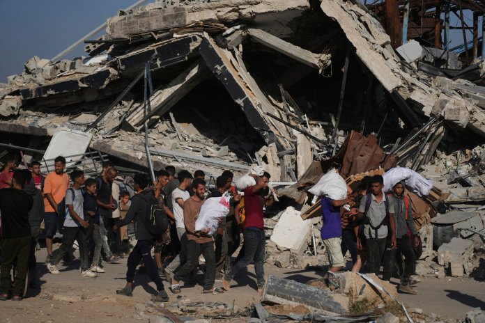 Palestinos cargan paquetes de ayuda distribuidos por la Fundación Humanitaria de Gaza, operada por una organización respaldada por EE. UU. Foto La Hora: AP
