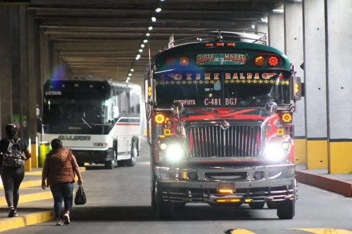 Dos buses salen de su estación en Guatemala.