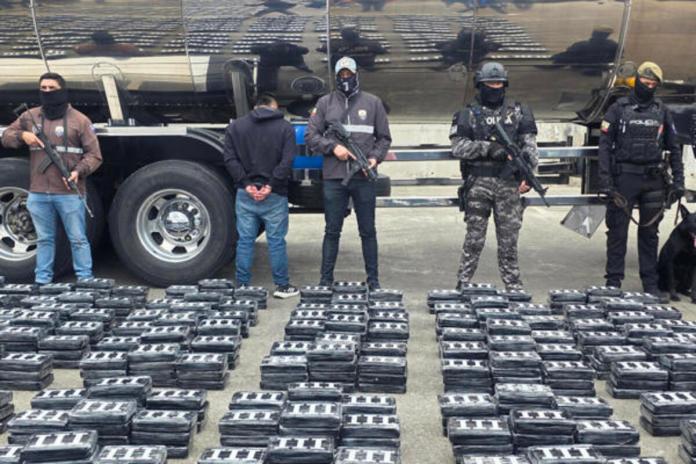 Agentes antidrogas de la Policía Nacional de Ecuador posan con un detenido y un cargamento de bloques de cocaína incautada. Foto La Hora: EFE.