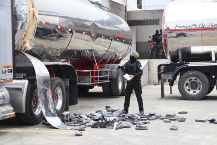 Un agente antidrogas de la Policía Nacional de Ecuador encuentra bloques de cocaína en un compartimento oculto de un camión. Foto La Hora: EFE.
