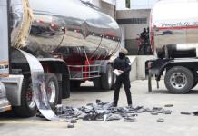 Un agente antidrogas de la Policía Nacional de Ecuador encuentra bloques de cocaína en un compartimento oculto de un camión. Foto La Hora: EFE.