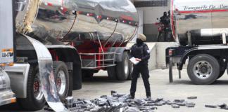 Un agente antidrogas de la Policía Nacional de Ecuador encuentra bloques de cocaína en un compartimento oculto de un camión. Foto La Hora: EFE.