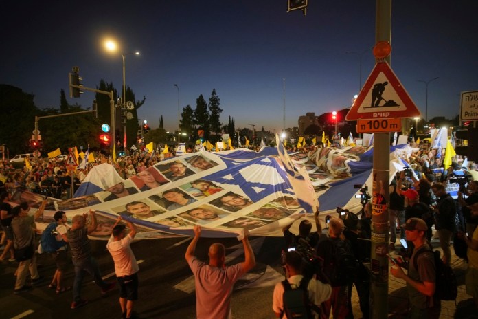 Parientes y simpatizantes de los rehenes israelíes retenidos en la Franja de Gaza participan en una marcha para exigir que Hamás los libere, y para pedir el fin de la guerra, el jueves 7 de agosto de 2025, frente a la oficina del primer ministro en Jerusalén. (AP Foto/Ohad Zwigenberg)