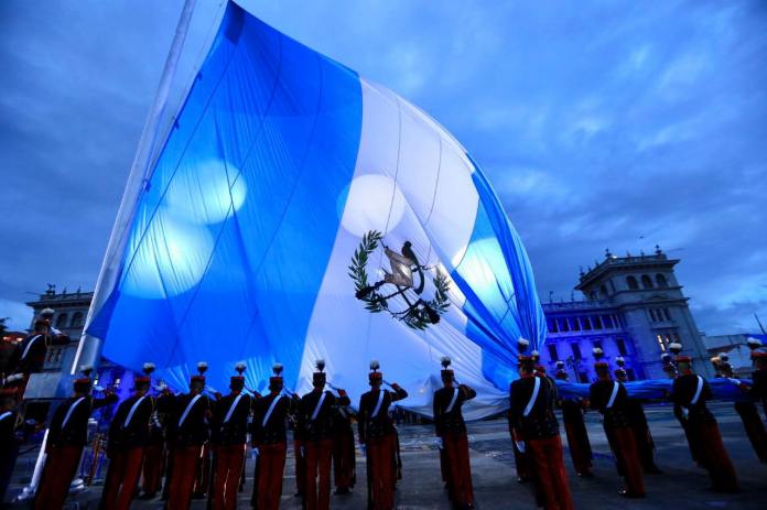 El pabellón nacional de Guatemala es desdoblado por al menos 15 cadetes. Foto La Hora: Facebook de Alejandro Giammattei.