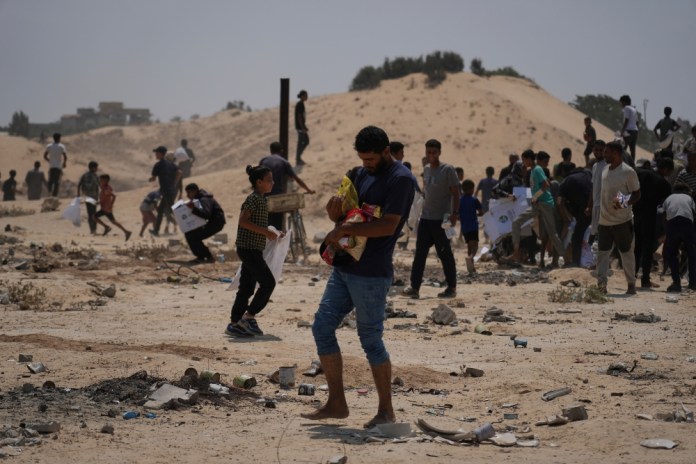 Palestinos reciben ayuda humanitaria de paquetes enviados por los Emiratos Árabes Unidos en Deir al-Balah, Franja de Gaza, el 9 de agosto del 2025. (AP foto/Abdel Kareem Hana)