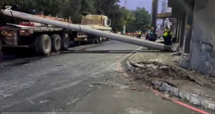 Un tráiler provocó serias complicaciones viales la mañana de este jueves 21 de agosto al derribar la carga de postes que transportaba sobre la ruta principal que conecta Prados de Villa Hermosa. Foto La Hora: Captura de Pantalla.