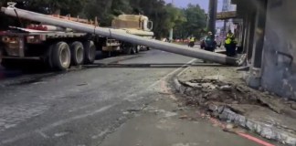 Un tráiler provocó serias complicaciones viales la mañana de este jueves 21 de agosto al derribar la carga de postes que transportaba sobre la ruta principal que conecta Prados de Villa Hermosa. Foto La Hora: Captura de Pantalla.