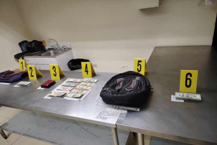 Una mujer tratada de viajar con dinero en efectivo que no fue reportado por la Superintendencia de Administración Tributaria (SAT). Foto: PNC