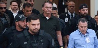 El expresidente Jair Bolsonaro, en el centro, al que se le permitió salir temporalmente del arresto domiciliario para recibir tratamiento médico, sale de un hospital en Brasilia, Brasil, el domingo 14 de septiembre de 2025. (AP Foto/Luis Nova)