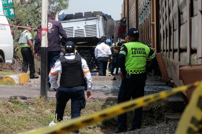 Integrantes de Policía resguardan la zona donde ocurrió el accidente entre un ferrocarril y un autobús. Foto La Hora: EFE