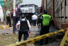 Integrantes de Policía resguardan la zona donde ocurrió el accidente entre un ferrocarril y un autobús. Foto La Hora: EFE
