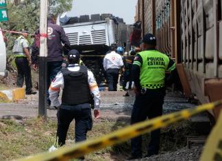 Integrantes de Policía resguardan la zona donde ocurrió el accidente entre un ferrocarril y un autobús. Foto La Hora: EFE