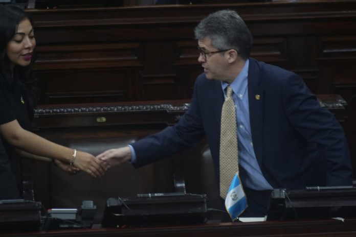 El ministro de Salud, Joaquín Barnoya, saluda a varios diputados previo a retomar la interpelación. Foto: La Hora / Fabricio Alonzo