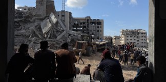 Un grupo de gazatíes observa los trabajos de rescate de cuatro personas (un padre y sus tres hijas), de entre los escombros tras un ataque aéreo israelí contra el edificio donde se refugiaban. Un total de 100 personas murieron, entre ellas 35 niños, en los bombardeos israelíes en la Franja palestina de Gaza, tras la reanudación anoche de los ataques del Ejército israelí en el enclave en lo que su Gobierno califica de violaciones del alto el fuego por Hamás.-EFE/ Ahmad Awad