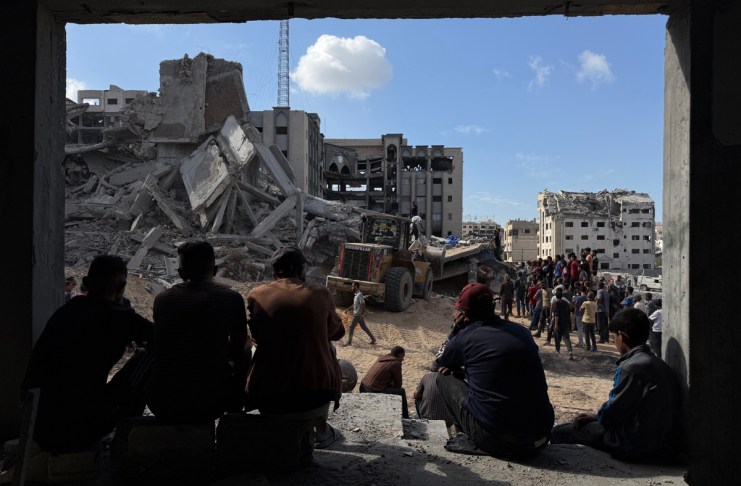 Un grupo de gazatíes observa los trabajos de rescate de cuatro personas (un padre y sus tres hijas), de entre los escombros tras un ataque aéreo israelí contra el edificio donde se refugiaban. Un total de 100 personas murieron, entre ellas 35 niños, en los bombardeos israelíes en la Franja palestina de Gaza, tras la reanudación anoche de los ataques del Ejército israelí en el enclave en lo que su Gobierno califica de violaciones del alto el fuego por Hamás.-EFE/ Ahmad Awad