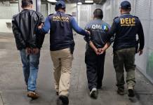 Agentes de la PNC con dos hombres deportados. Foto La Hora: PNC
