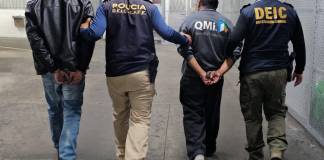 Agentes de la PNC con dos hombres deportados. Foto La Hora: PNC