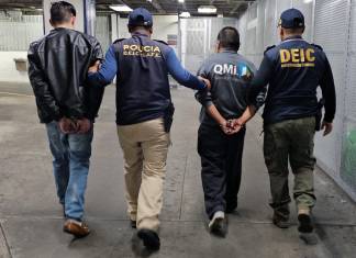 Agentes de la PNC con dos hombres deportados. Foto La Hora: PNC