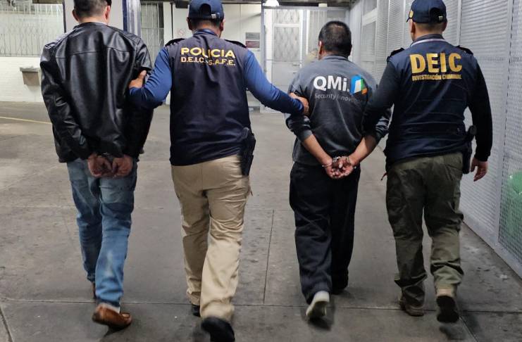 Agentes de la PNC con dos hombres deportados. Foto La Hora: PNC