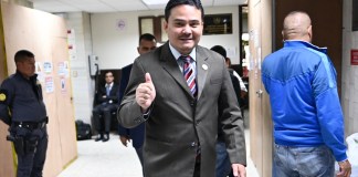 El sancionado juez Fredy Orellana levanta el pulgar al ser fotografiado a su salida del Juzgado Séptimo Penal A. Foto La Hora: Fabricio Alonzo.