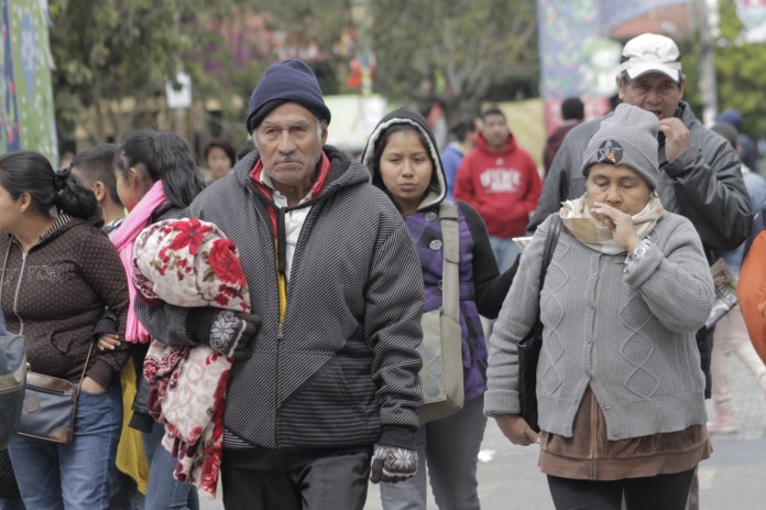 Personas caminando bien abrigadas.