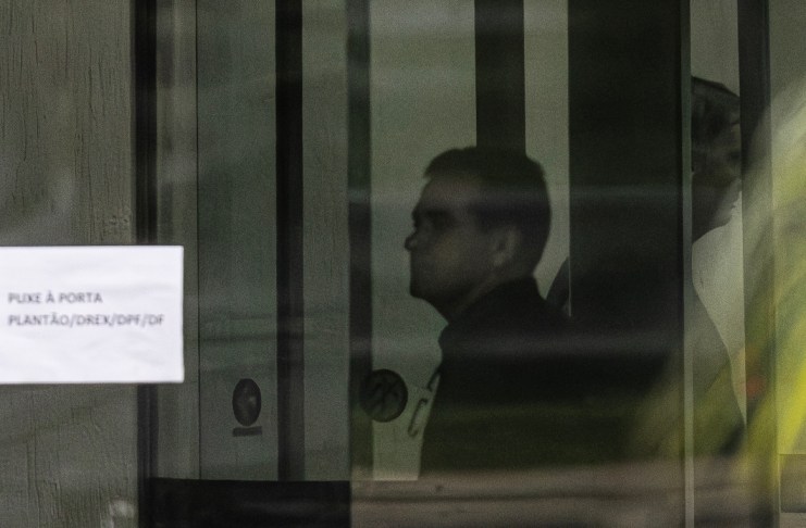 Fotografía que muestra al expresidente de Brasil Jair Bolsonaro (d) detrás de una puerta de vidrio este domingo, en la Superintendencia de la Policía Federal en Brasilia. Foto La Hora: EFE