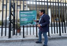 El diputado José Chic cuelga una pancarta frente al Ministerio Público en contra de Alejandro Giammattei y Miguel Martínez. Foto: Cortesía