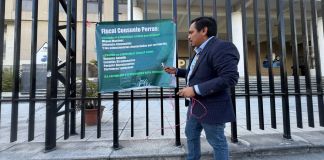 El diputado José Chic cuelga una pancarta frente al Ministerio Público en contra de Alejandro Giammattei y Miguel Martínez. Foto: Cortesía