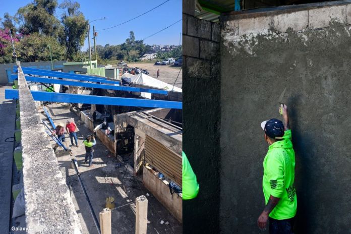 Empleados municipales realizan las mejoras en el techo y paredes de los puestos de venta en el mercado la Carolingia. Foto La Hora: Neto Bran