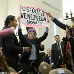 La integrante de la organización feminista CodePink, Medea Benjamin, sostiene un cartel durante una sesión extraordinaria del Consejo Permanente de la OEA en Washington. Foto La Hora: EFE