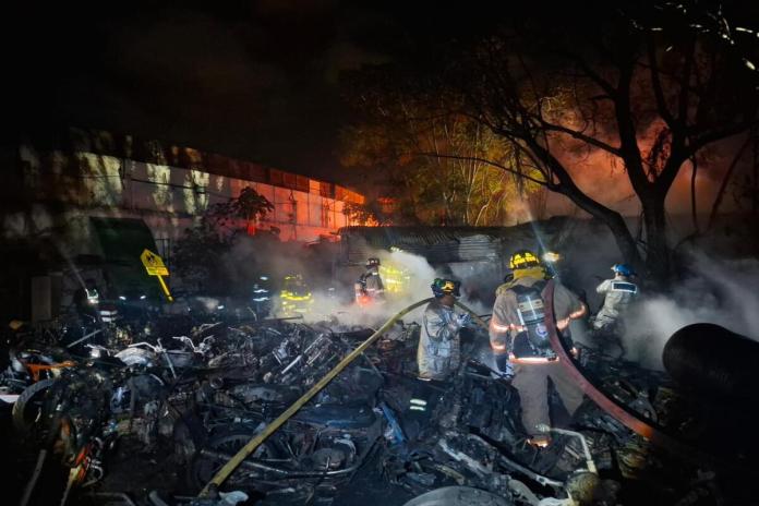 Socorristas apagan las llamas en el predio de motocicletas en Antigua Guatemala. Foto: Bomberos Voluntarios.