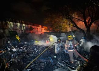 Socorristas apagan las llamas en el predio de motocicletas en Antigua Guatemala. Foto: Bomberos Voluntarios.