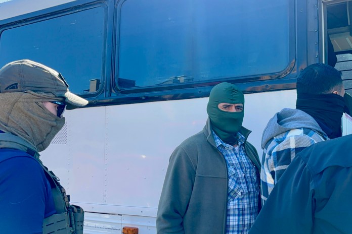 Agentes del Servicio de Inmigración y Control de Aduanas (ICE) esperan afuera de la corte de inmigración, en San Antonio, Texas. Foto La Hora: EFE