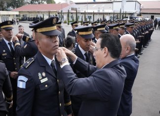El ministro de Gobernación, Marco Antonio Villeda, coloca insignias en la graduación de los nuevos oficiales terceros de la Policía Nacional Civil. Foto: Ministerio de Gobernación