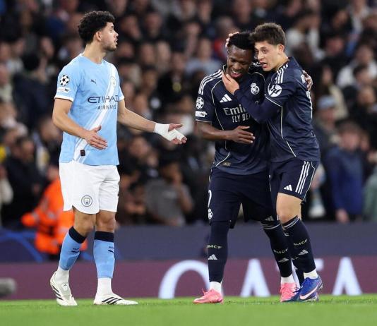 El jugador brasileño del Real Madrid Vinicius Junior (C) celebra con Arda Güler un gol durante el partido de vuelta de octavos de la UEFA Champions League que han jugado Manchester City y Real Madrid en Manchester, Reino Unido. EFE/EPA/ADAM VAUGHAN