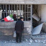 Un hombre observa una vivienda dañada por bombardeos