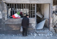 Un hombre observa una vivienda dañada por bombardeos