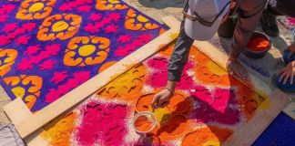 Persona realizando una alfombra de aserrín en Semana Santa. Foto La Hora: MInex