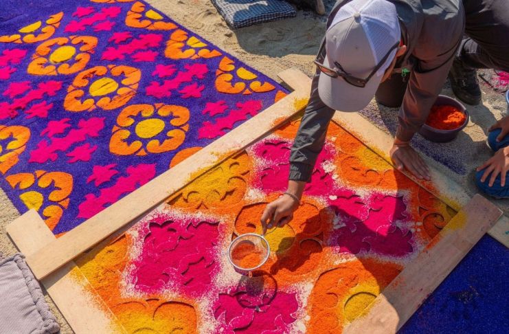Persona realizando una alfombra de aserrín en Semana Santa. Foto La Hora: MInex