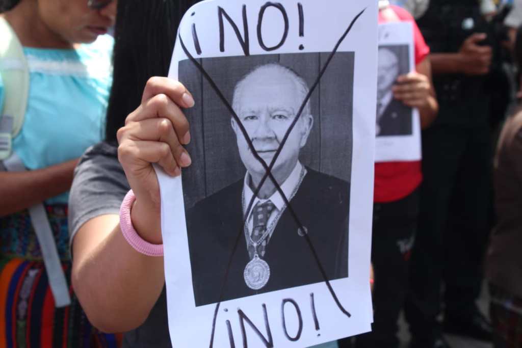 Varios ciudadanos protestaron con hojas en donde reclamaban que no se reeligiera a Roberto Molina Barreto. Foto La Hora: Kenneth Jordan.