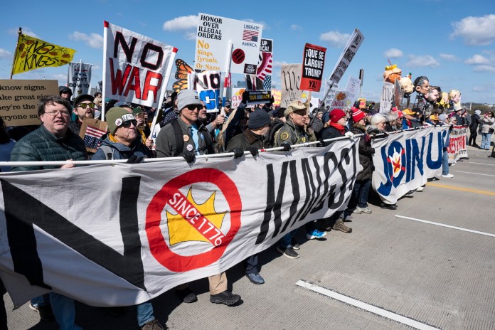 Las personas sostienen carteles y pancartas mientras participan en la marcha 'No Kings' (No reyes) en Washington.